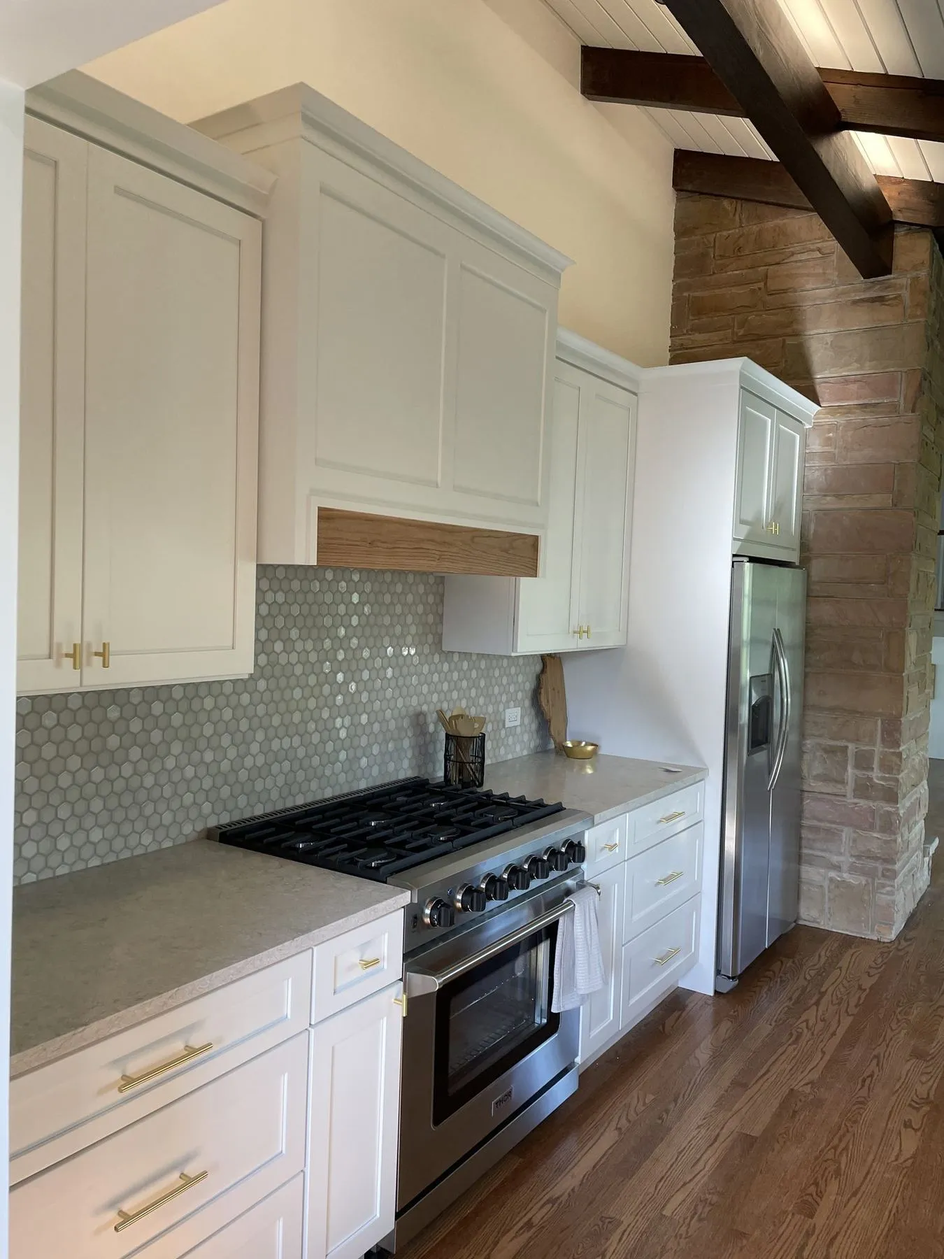 Range wall with white cabinets and a tile backsplash