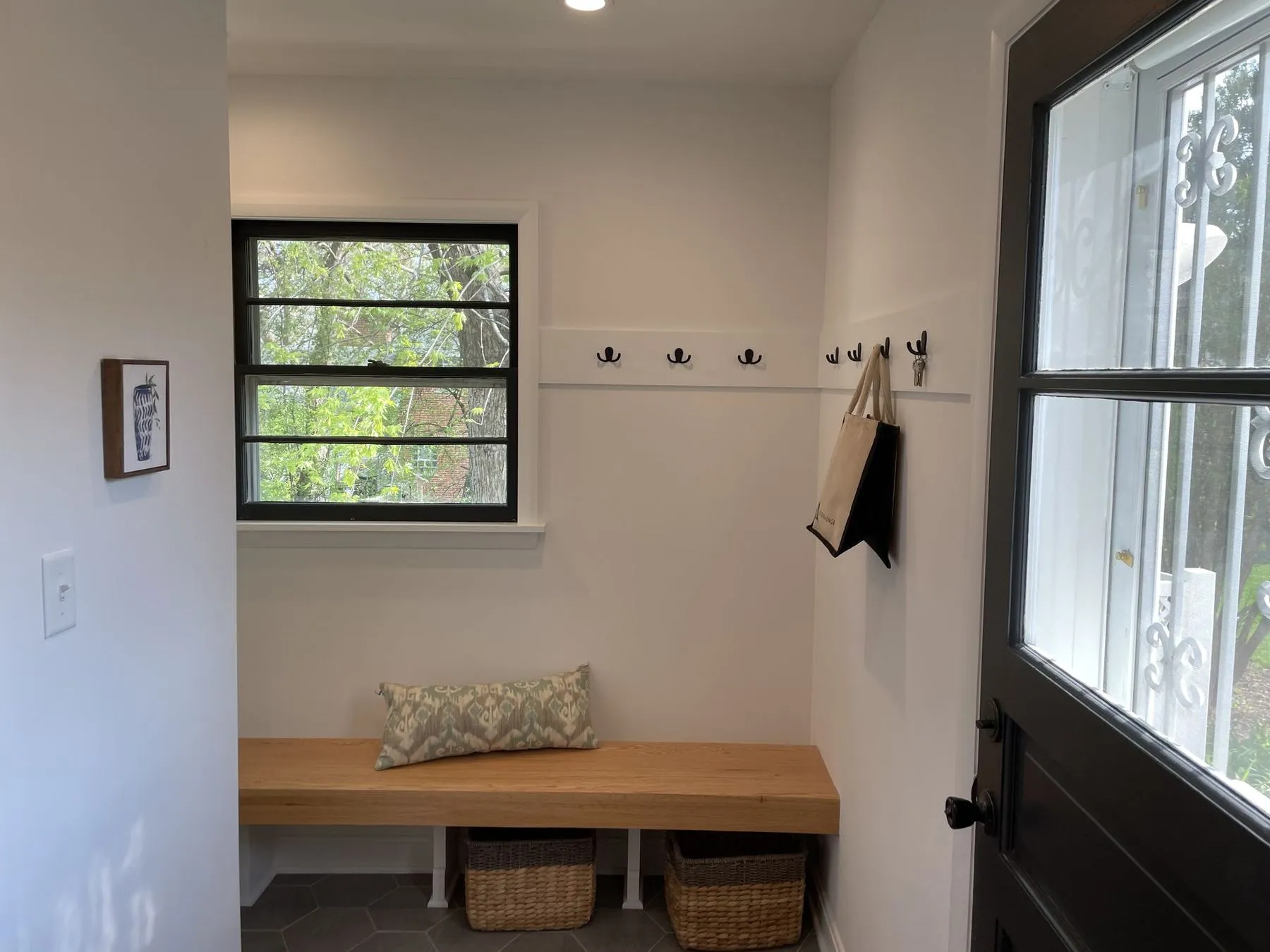 Mudroom bench with hooks beside the back door