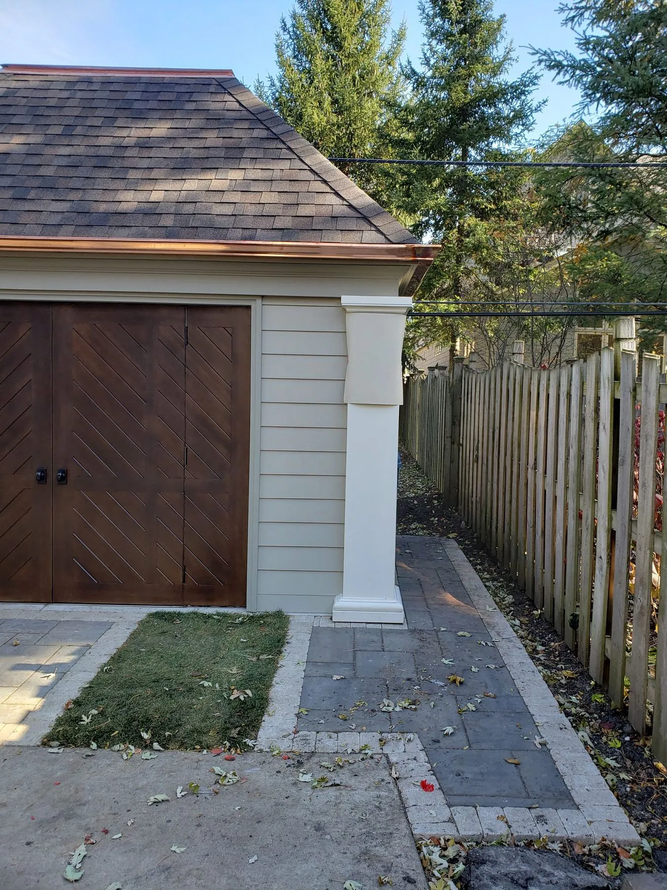 Garage with wood doors and a paver walk