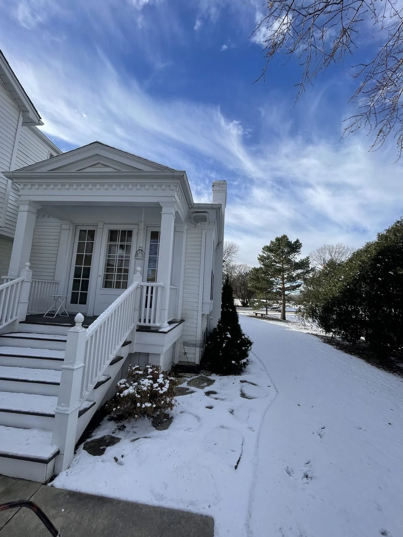 White portico with columns, French doors, and new steps