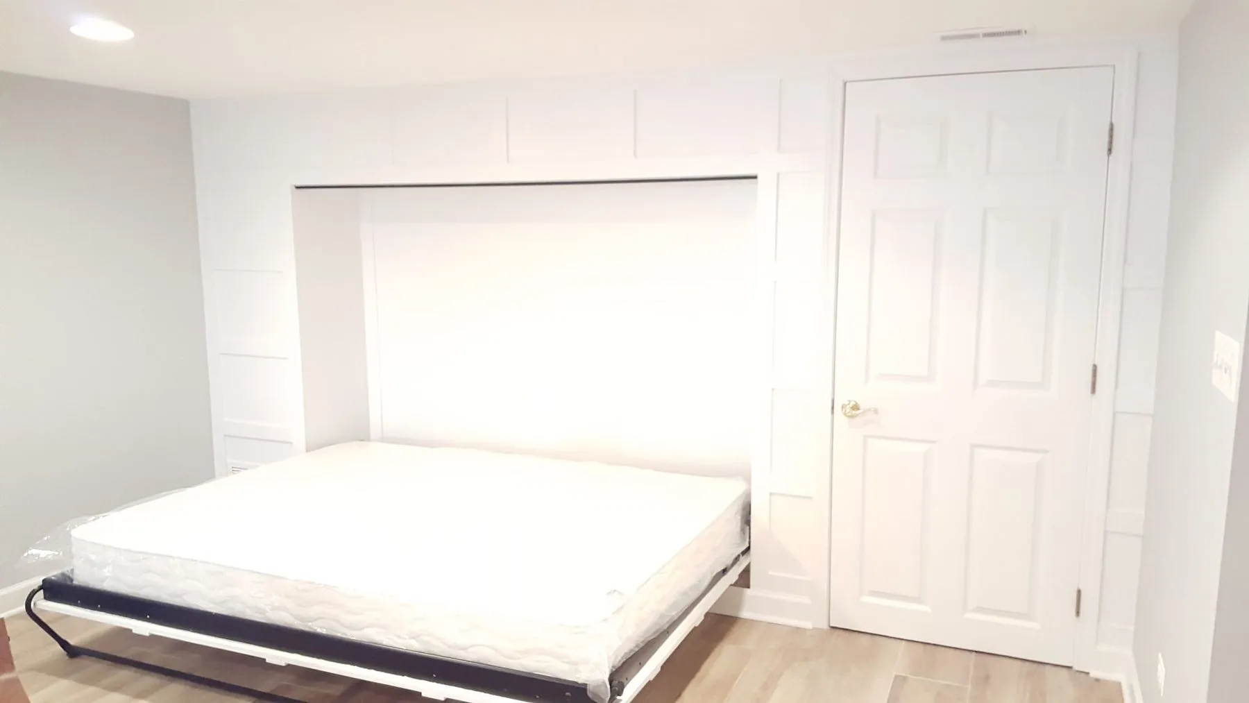 Bed folded down from the paneled wall