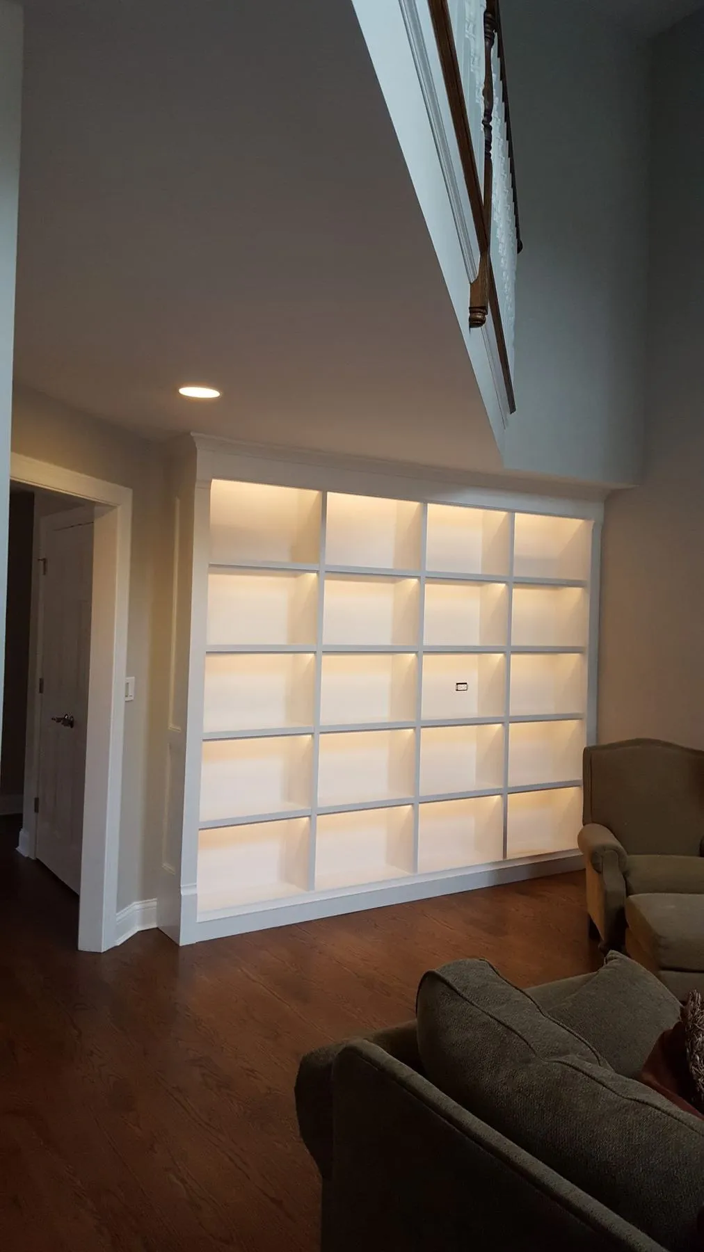 Wall of lit built-in shelves in a living room