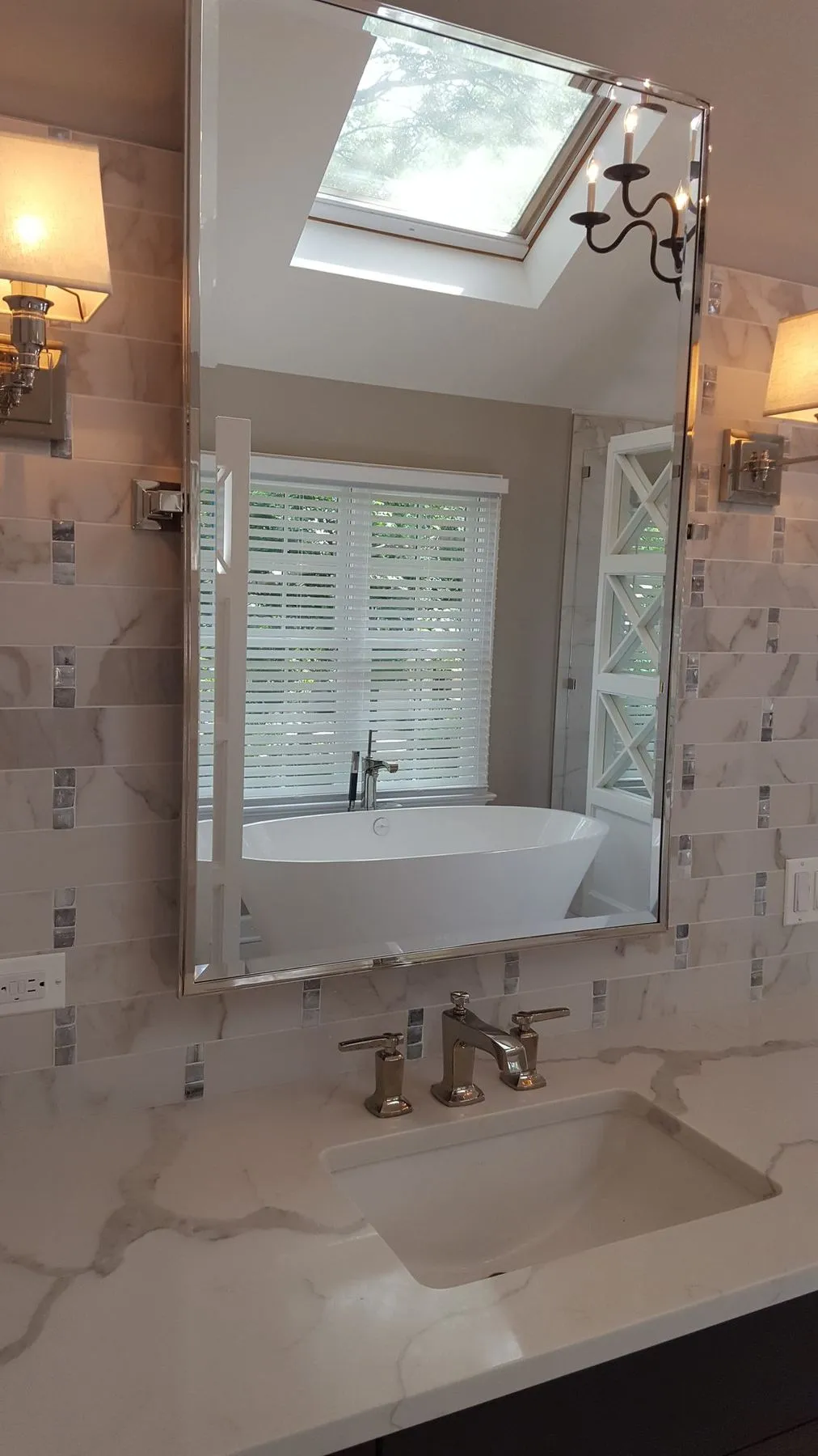 Mirror reflecting the tub and skylight