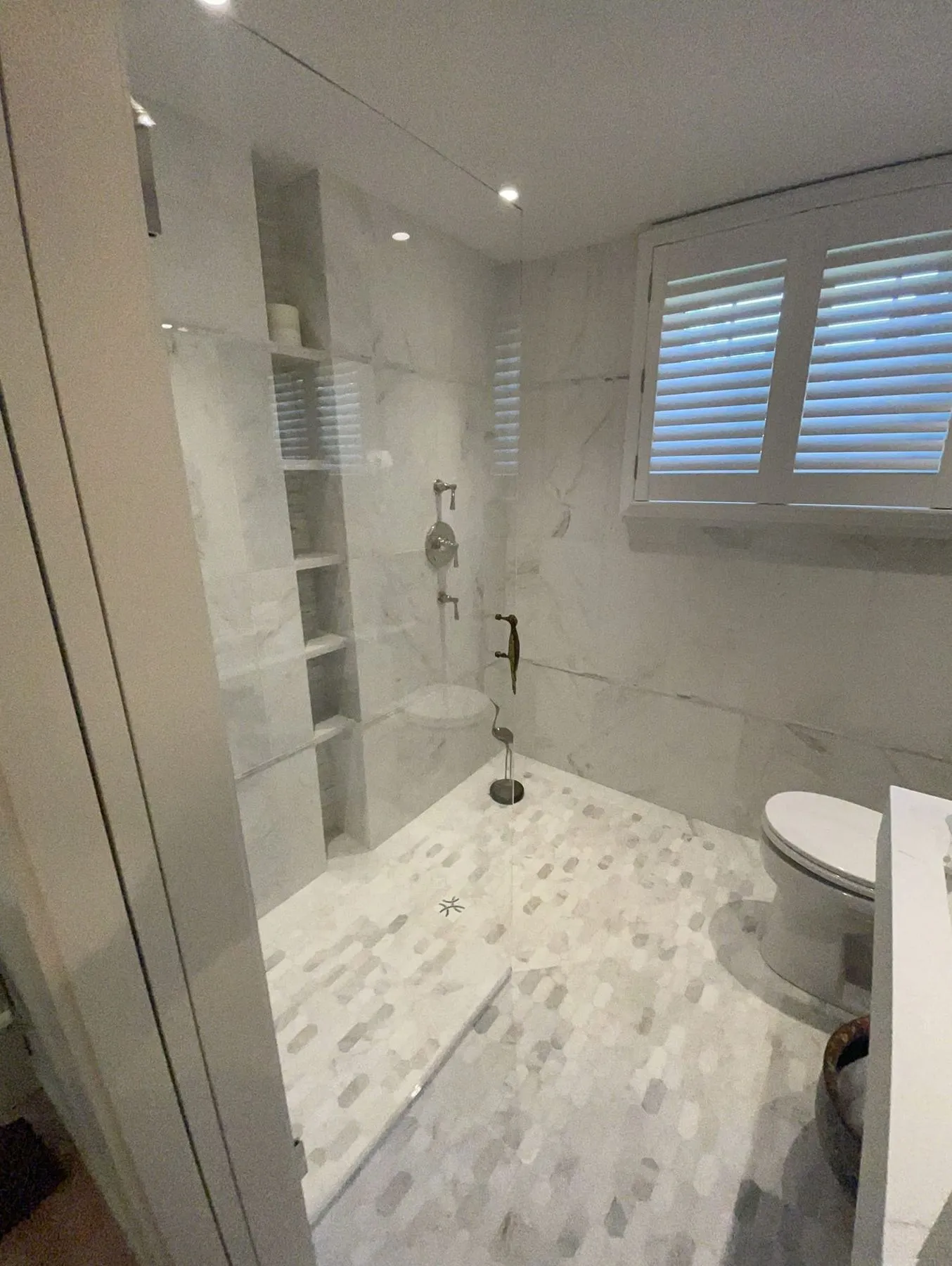 Shower and toilet area with a mosaic floor