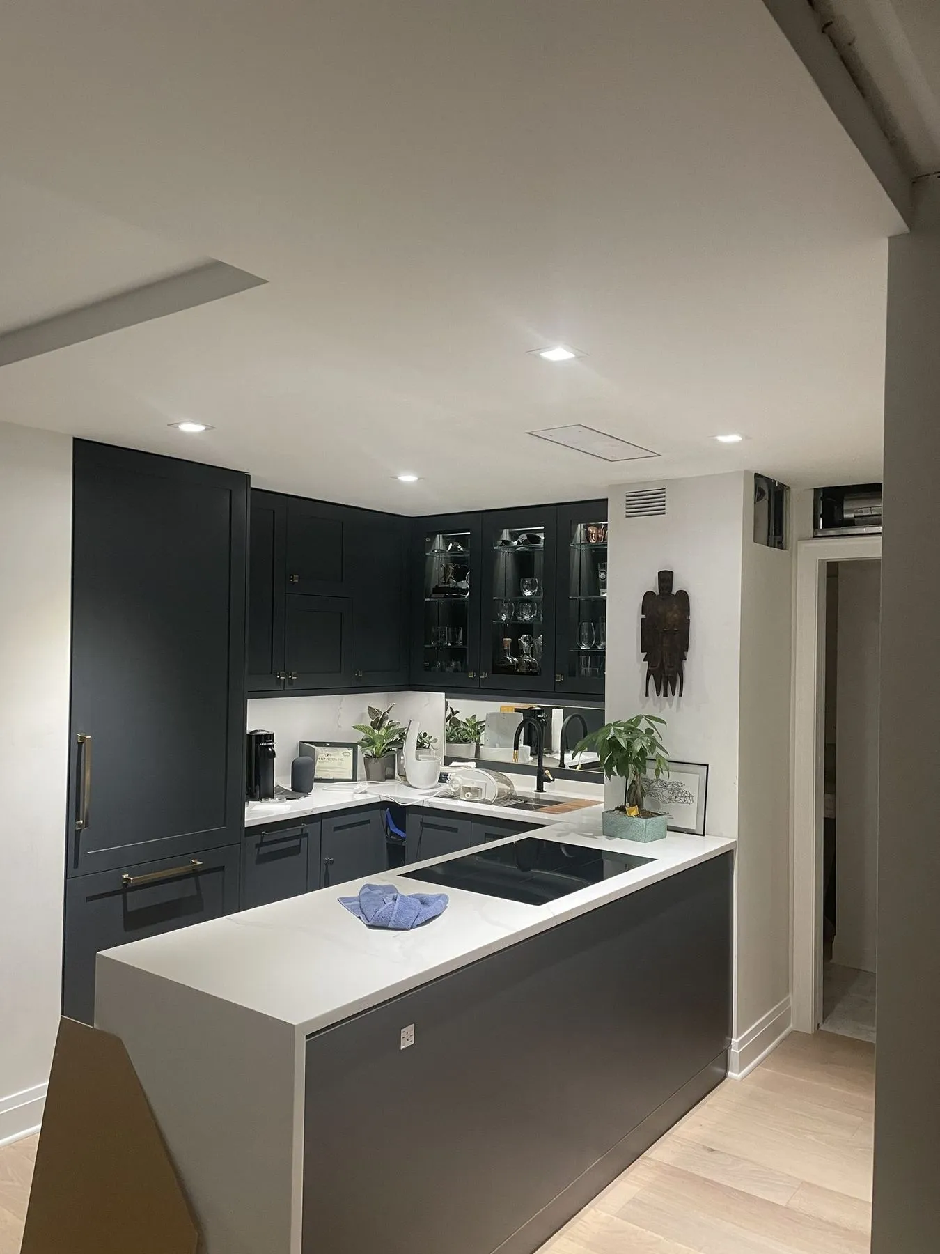 Navy cabinets and a peninsula with a cooktop