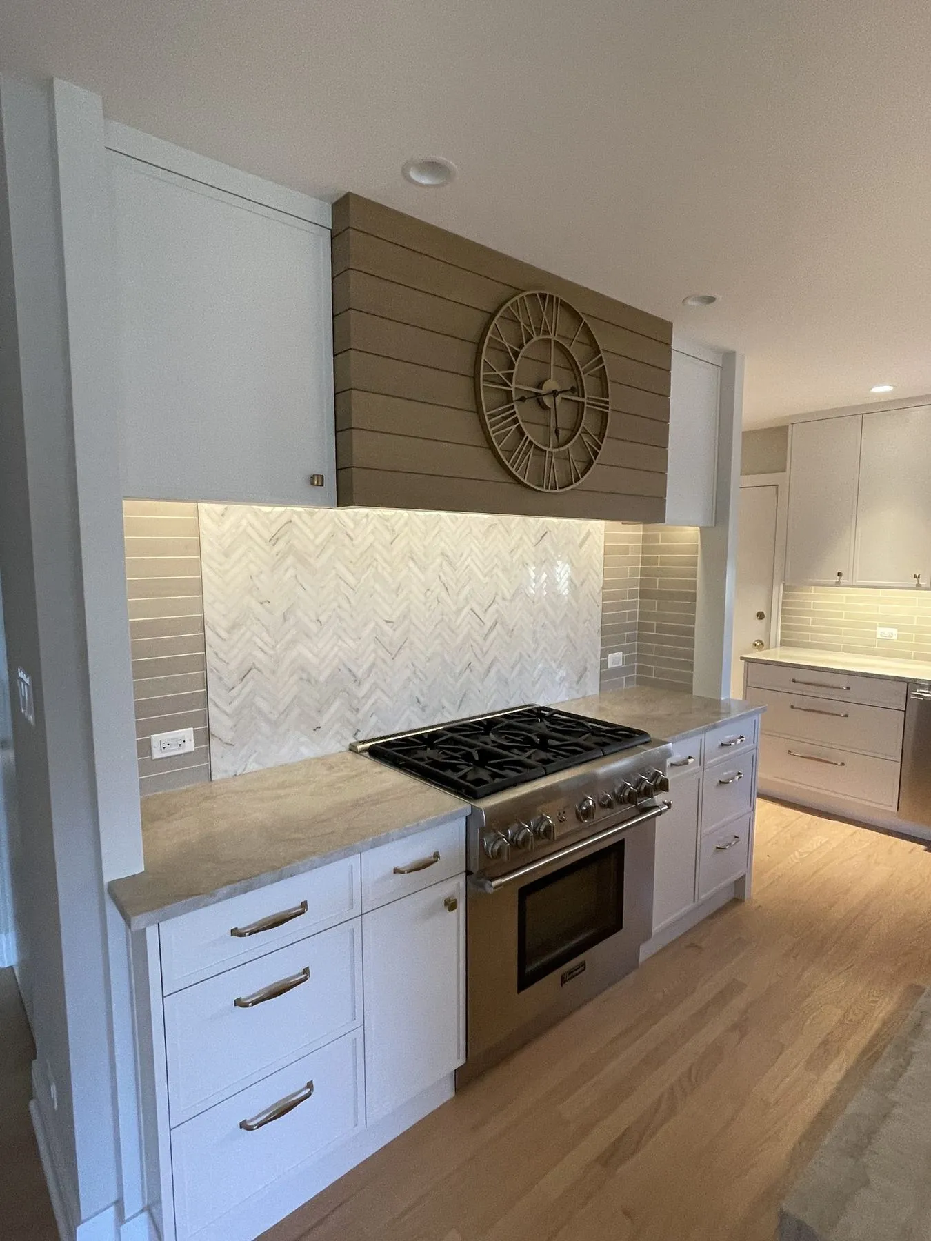 Range wall with plank hood and lit backsplash